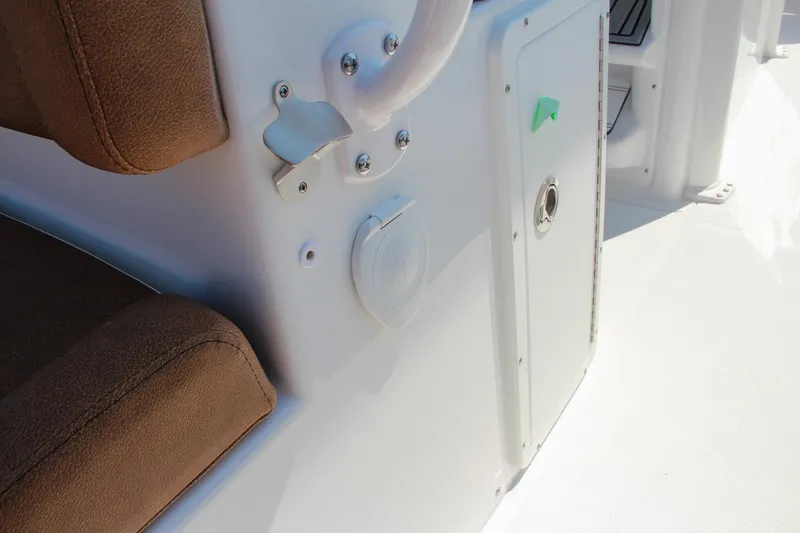 Slide: The Image of 2025 Sea Hunt Ultra 275 SE boat interior with brown seating and white panel. - 27