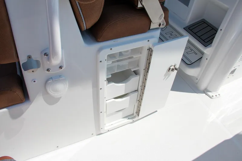 Slide: The Image of 2025 Sea Hunt Ultra 275 SE boat storage compartment with open door and seating. - 34
