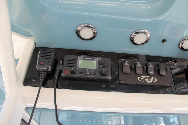 Slide: The Image of Control panel of 2025 Sea Hunt Ultra 275 SE boat with radio and switches. - 46
