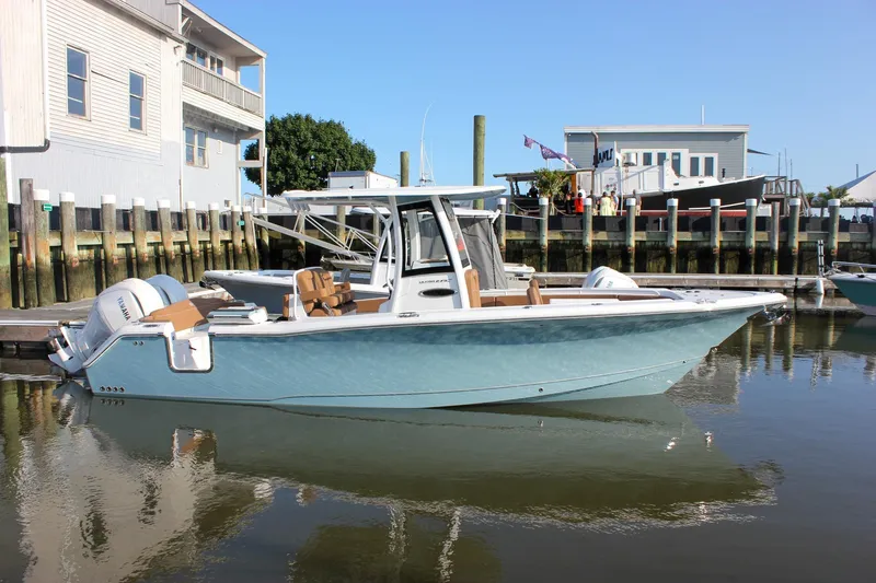 Slide: The Image of 2025 Sea Hunt Ultra 275 SE boat docked in marina, featuring sleek design and dual engines. - 69