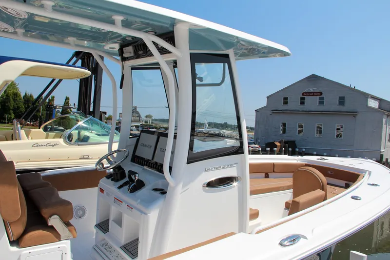 Slide: The Image of 2025 Sea Hunt Ultra 275 SE boat with modern console and seating, docked at marina. - 7