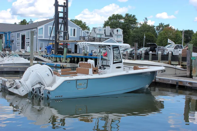 Slide: The Image of 2025 Sea Hunt Ultra 275 SE boat docked at a marina with blue sky background. - 70