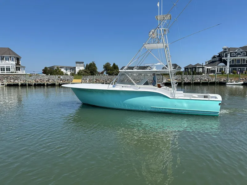 Slide: The Image of 2002 Custom Carolina 40 Express Sportfisherman in a serene marina setting. - 14