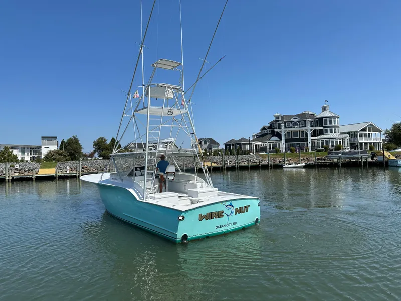 Slide: The Image of 2002 Custom Carolina 40 Express Sportfisherman in marina, clear sky, waterfront homes. - 15