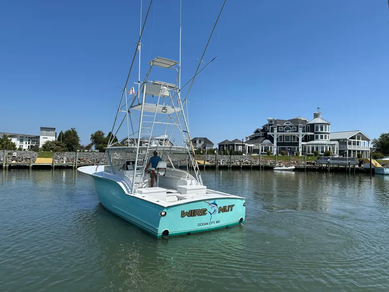 Slide: The Image of Custom Carolina 40 Express Sportfisherman, 2002, cruising near waterfront homes under clear blue sky. - 16