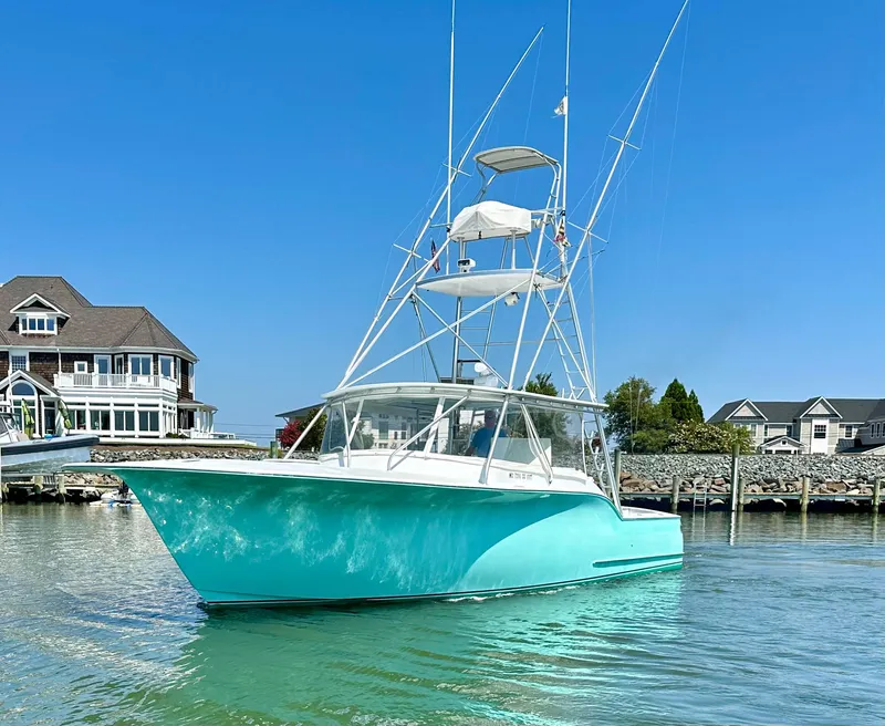 Slide: The Image of 2002 Custom Carolina 40 Express Sportfisherman in serene waters near waterfront homes. - 21
