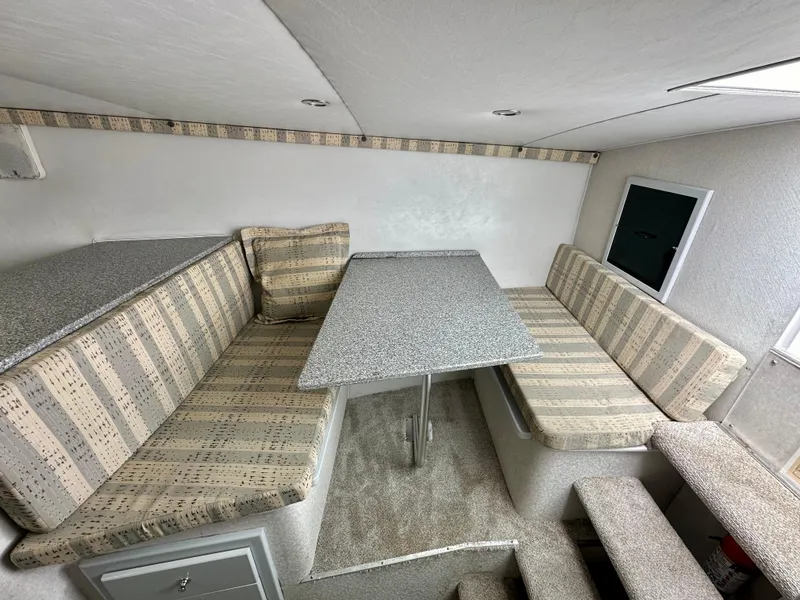 Slide: The Image of Interior of 2002 Custom Carolina 40 Express Sportfisherman with striped seating and table. - 25