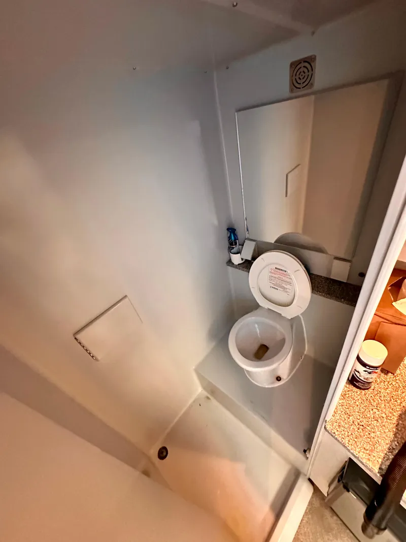 Slide: The Image of Compact bathroom in 2002 Custom Carolina 40 Express Sportfisherman boat, featuring toilet and mirror. - 26