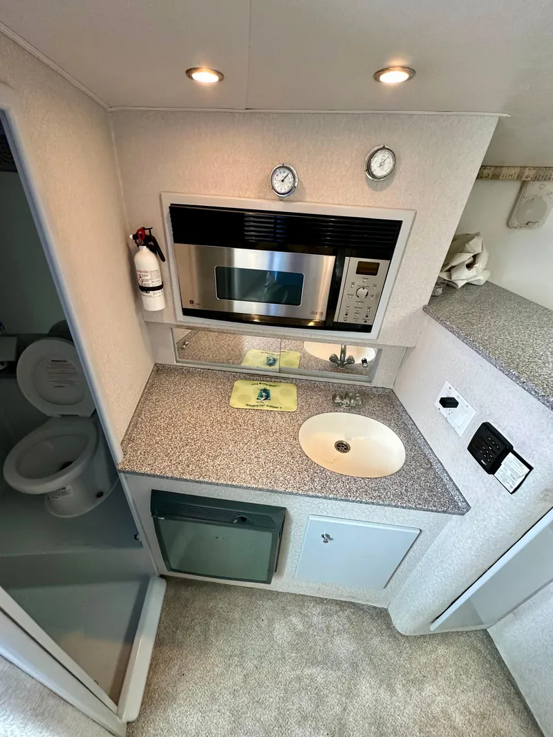 Slide: The Image of Compact galley in 2002 Custom Carolina 40 Express Sportfisherman with microwave, sink, and storage. - 27