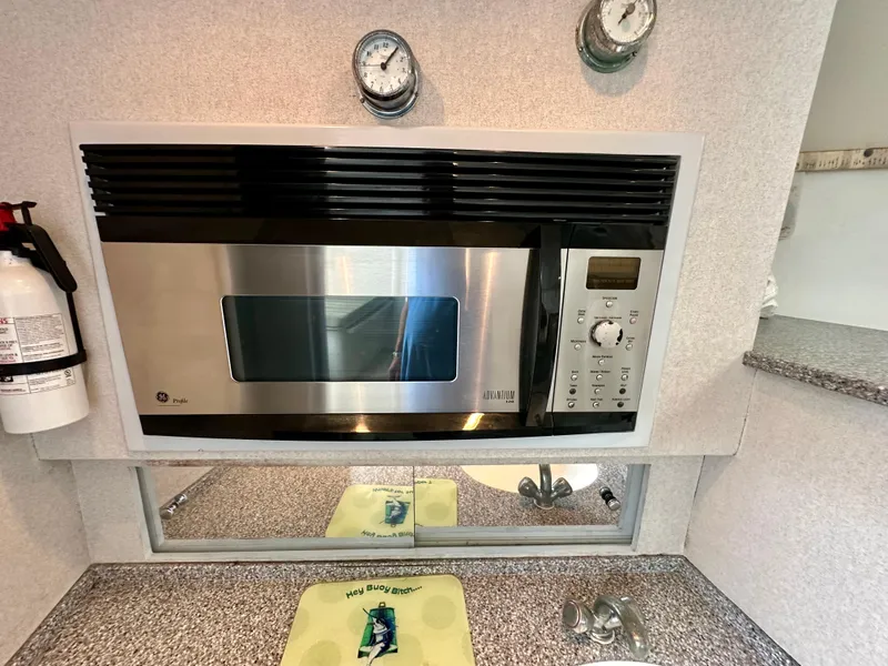 Slide: The Image of Microwave in 2002 Custom Carolina 40 Express Sportfisherman kitchen with countertop and fire extinguisher. - 29
