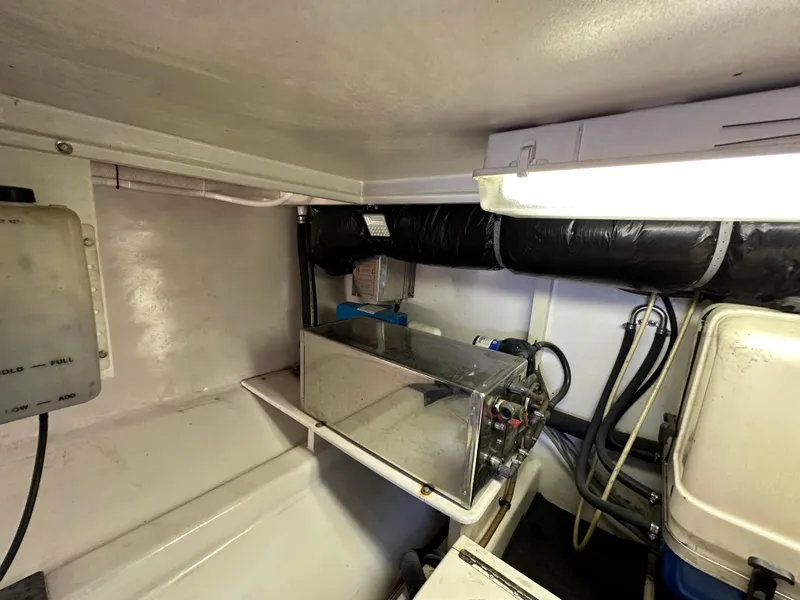 Slide: The Image of Engine room of 2002 Custom Carolina 40 Express Sportfisherman, featuring mechanical components and storage. - 36