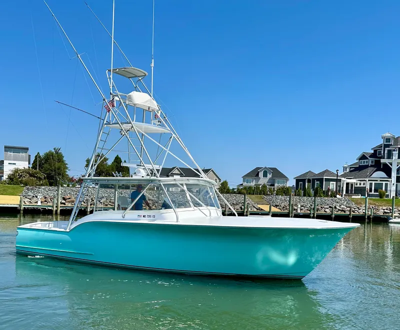 Slide: The Image of 2002 Custom Carolina 40 Express Sportfisherman in marina, clear sky, waterfront homes. - 4