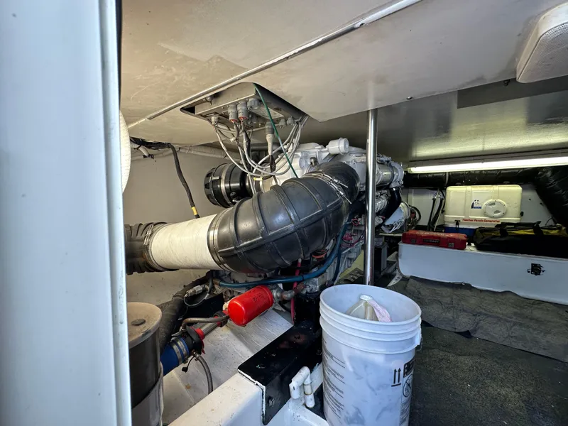 Slide: The Image of Engine room of 2002 Custom Carolina 40 Express Sportfisherman, featuring mechanical components and storage. - 42