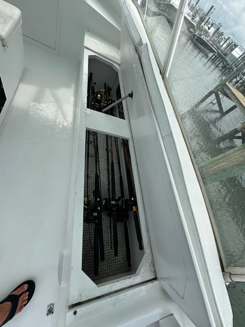 Slide: The Image of Storage compartment with fishing rods on a 2002 Custom Carolina 40 Express Sportfisherman boat. - 43