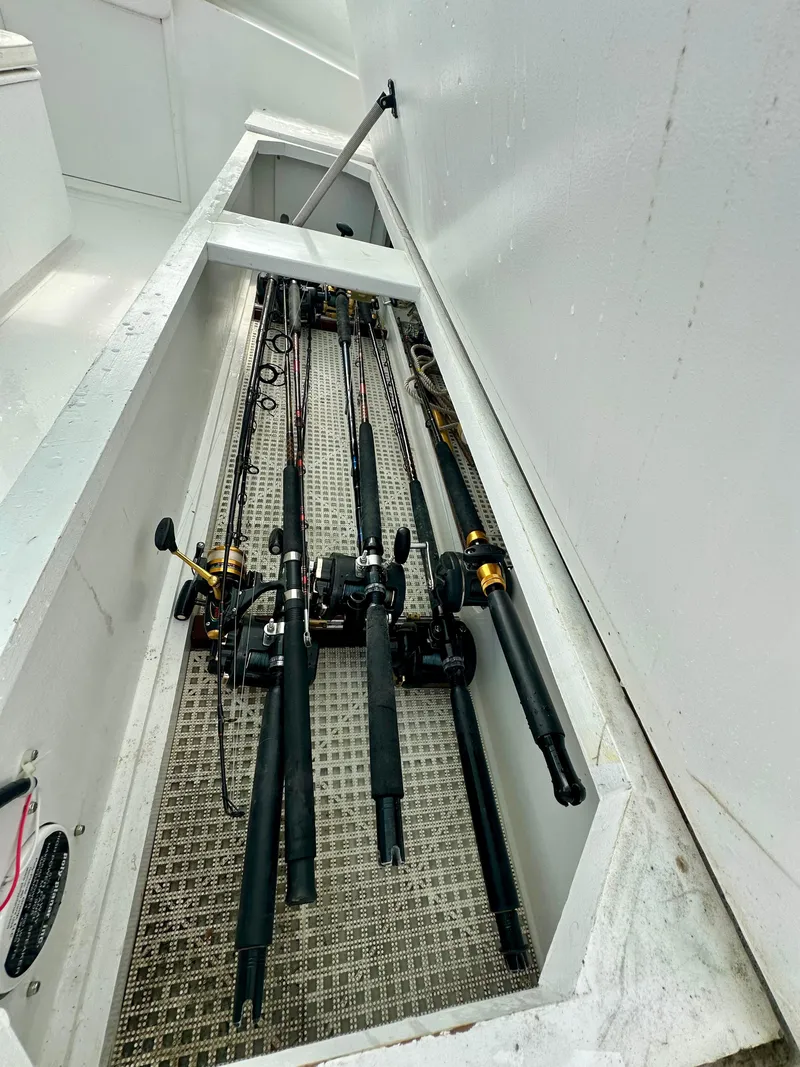 Slide: The Image of Fishing rods stored in a compartment on a 2002 Custom Carolina 40 Express Sportfisherman. - 44