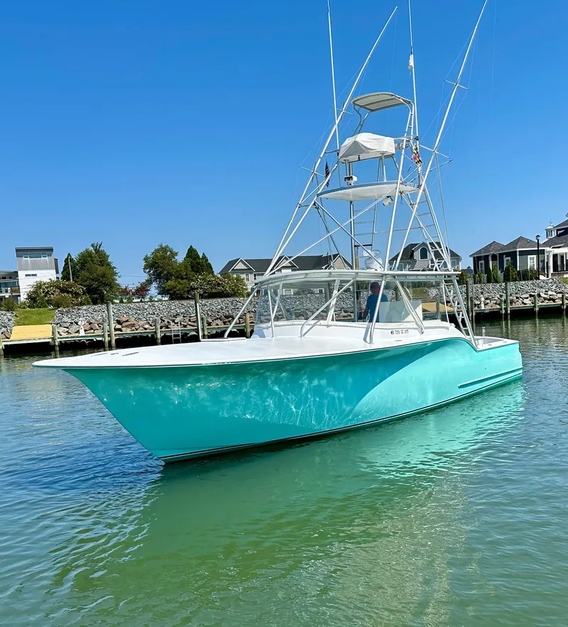 Slide: The Image of 2002 Custom Carolina 40 Express Sportfisherman in turquoise, docked in a serene marina. - 9
