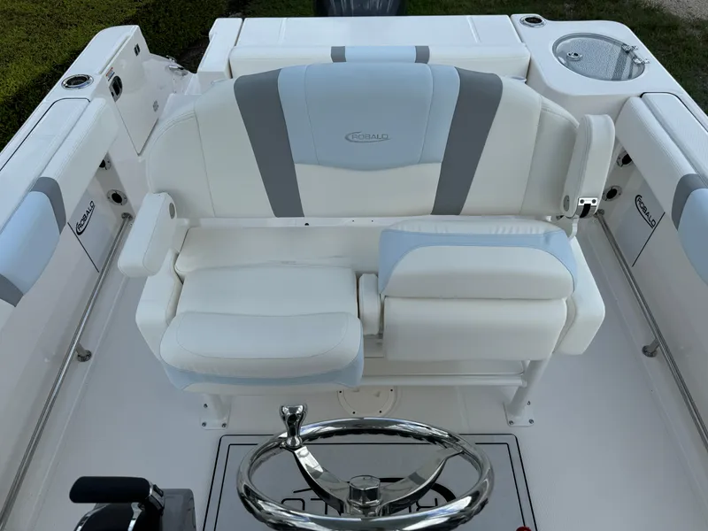 Slide: The Image of 2025 Robalo R230 Center Console boat interior with cushioned seating and steering wheel. - 19