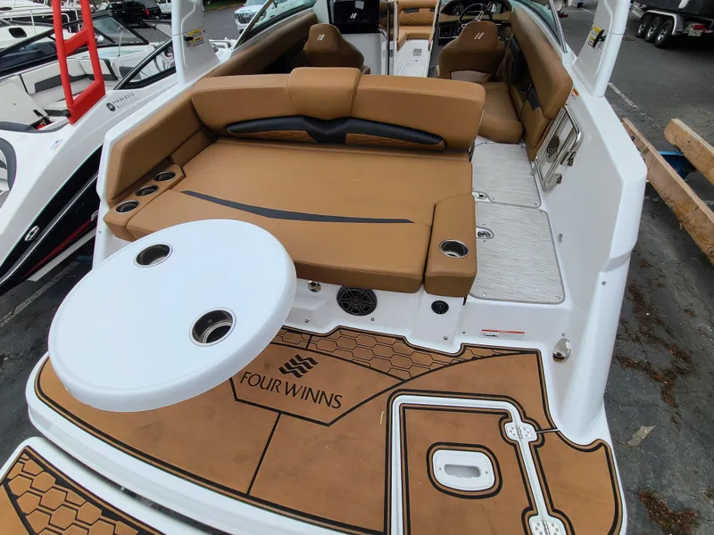 Slide: The Image of 2023 Four Winns HD5 boat interior with tan seating and white table. - 10
