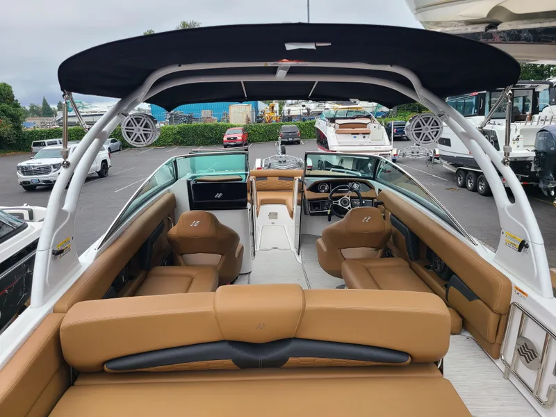 Slide: The Image of 2023 Four Winns HD5 boat interior with tan seating and black canopy. - 11