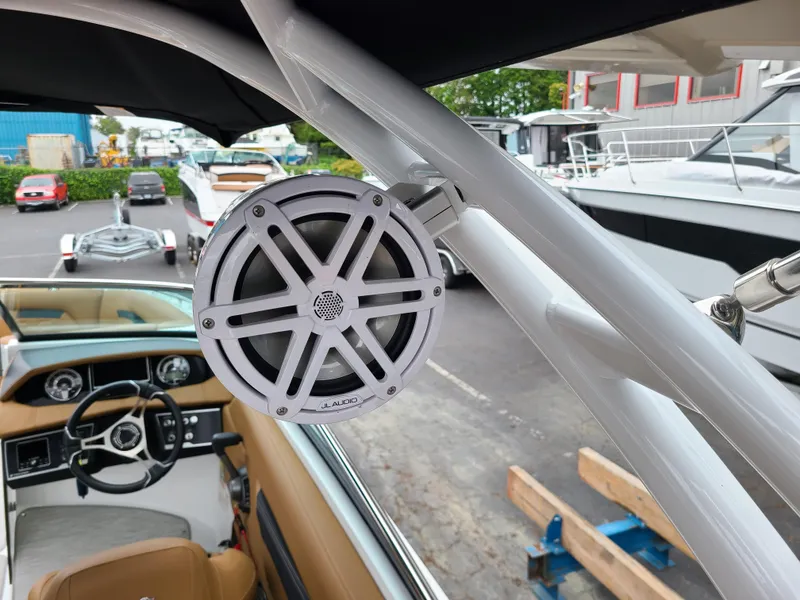 Slide: The Image of 2023 Four Winns HD5 boat with speaker system, docked in a marina. - 12