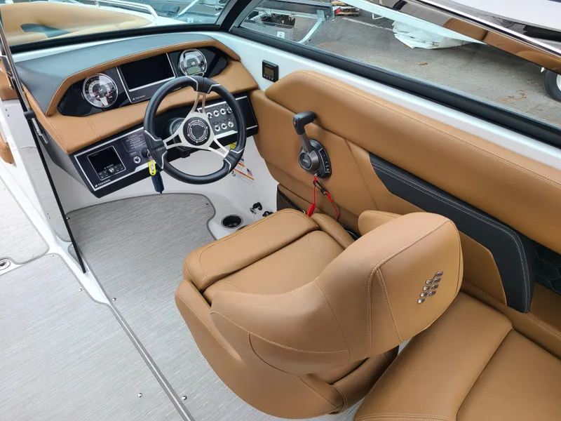 Slide: The Image of 2023 Four Winns HD5 boat interior with tan leather seating and modern dashboard. - 6