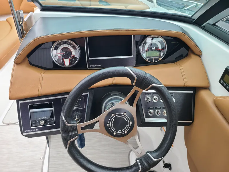 Slide: The Image of 2023 Four Winns HD5 boat dashboard with steering wheel and control panel. - 7