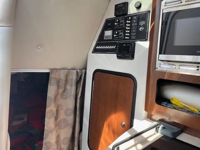 Slide: The Image of 2023 Crownline 270 CR cabin interior with control panel and microwave. - 26