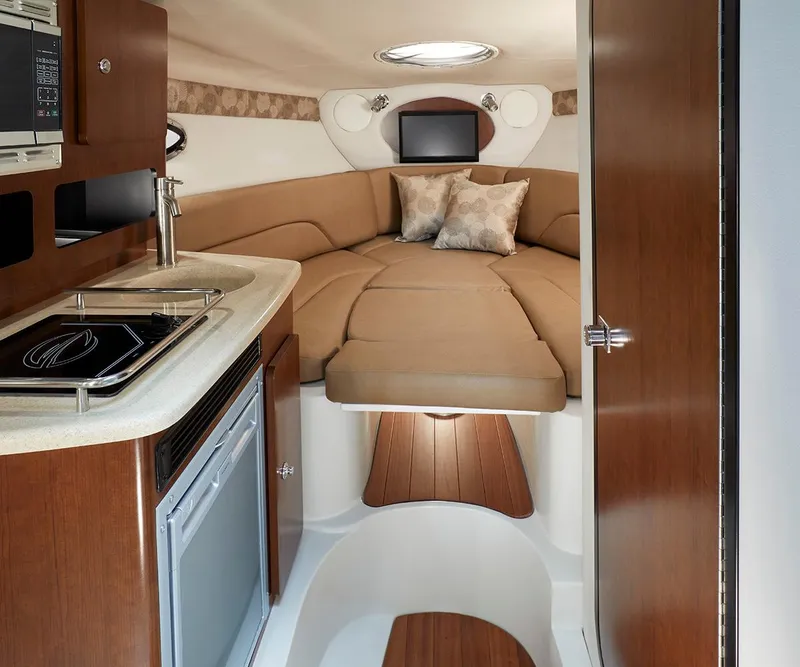 Slide: The Image of Luxurious interior of 2023 Crownline 270 CR boat with kitchenette and cozy sleeping area. - 30
