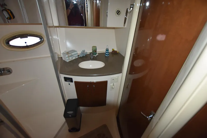 Slide: The Image of 2007 Carver 36 Mariner bathroom with sink, mirror, and wooden cabinetry. - 14