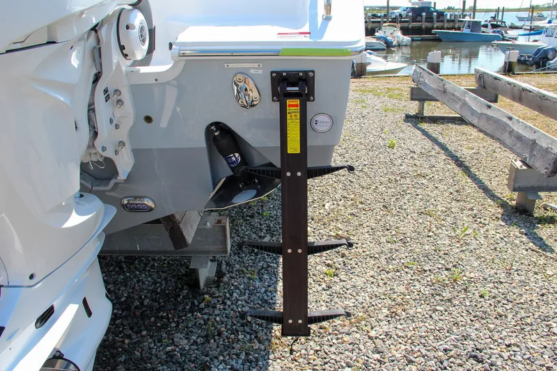 Slide: The Image of 2025 Sea Hunt Ultra 275 SE boat with ladder on gravel near marina. - 12