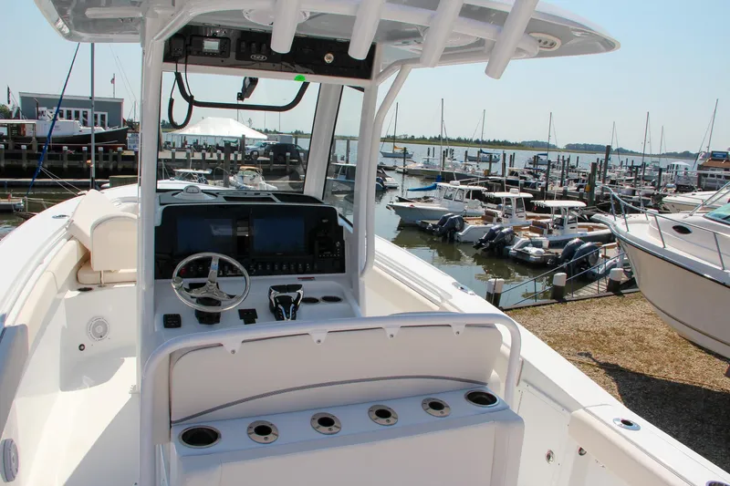 Slide: The Image of 2025 Sea Hunt Ultra 275 SE boat interior at marina, featuring helm and seating. - 23