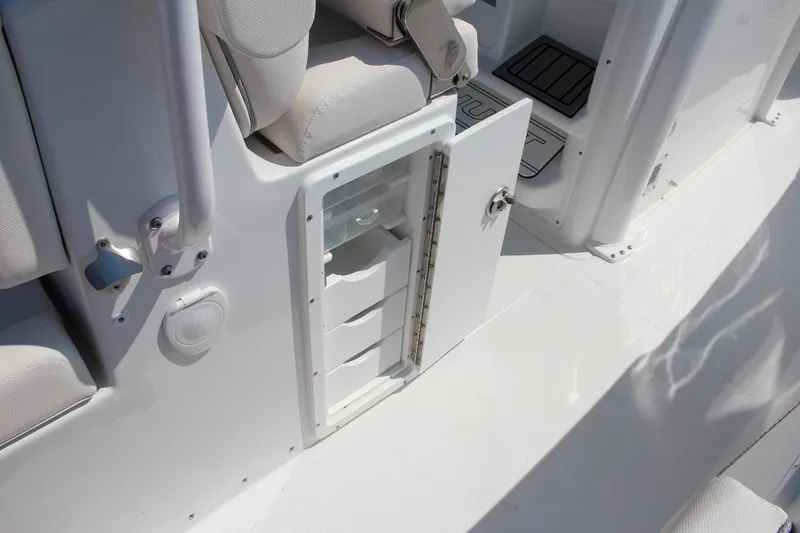 Slide: The Image of 2025 Sea Hunt Ultra 275 SE boat interior storage compartment with open door. - 33