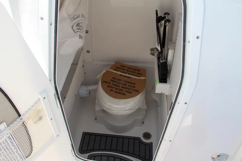Slide: The Image of 2025 Sea Hunt Ultra 275 SE boat bathroom interior with toilet and storage. - 40