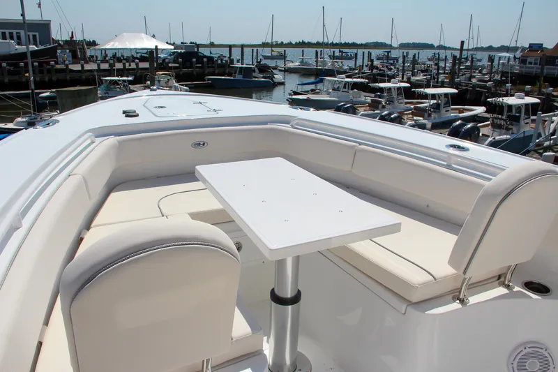Slide: The Image of 2025 Sea Hunt Ultra 275 SE boat with spacious seating and table in marina setting. - 42