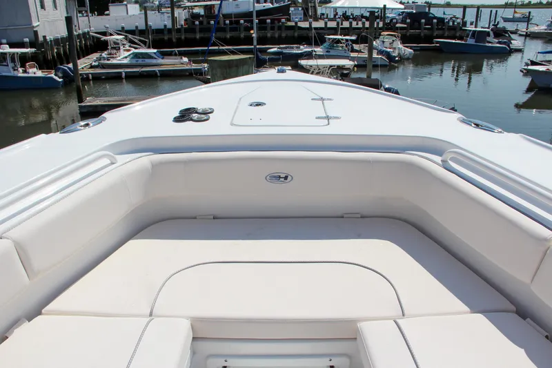 Slide: The Image of 2025 Sea Hunt Ultra 275 SE boat interior at marina, showcasing spacious seating. - 51