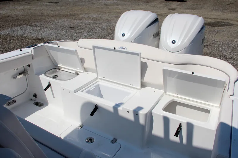 Slide: The Image of 2025 Sea Hunt Ultra 275 SE boat with open storage compartments and dual engines. - 9