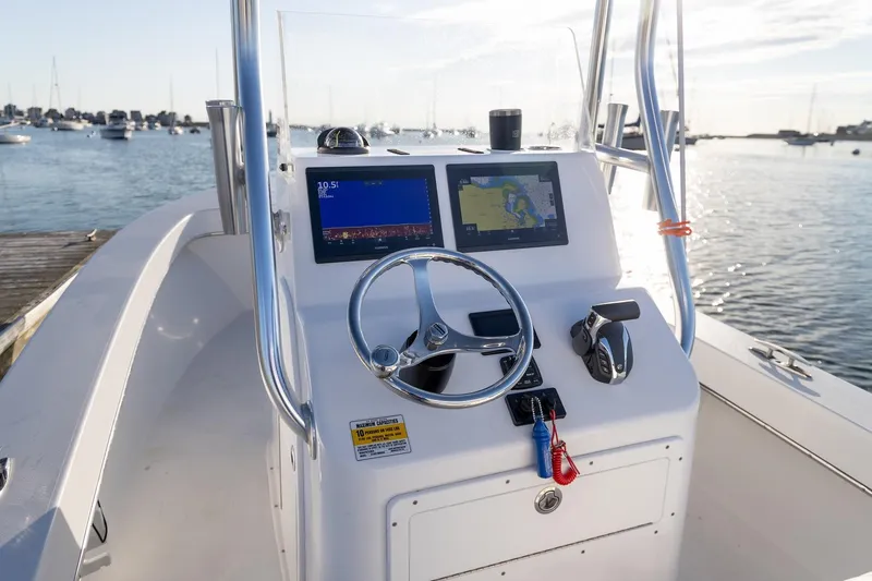 Slide: The Image of 2024 Jones Brothers 23 Cape Fisherman boat console with navigation screens and steering wheel. - 8