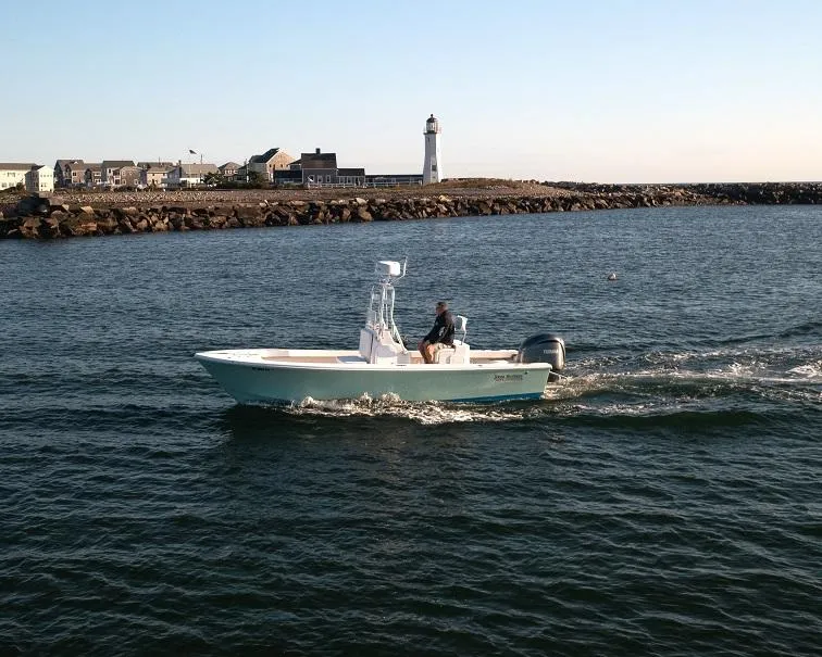 Slide: The Image of 2024 Jones Brothers 23 Cape Fisherman boat cruising near a lighthouse. - 9