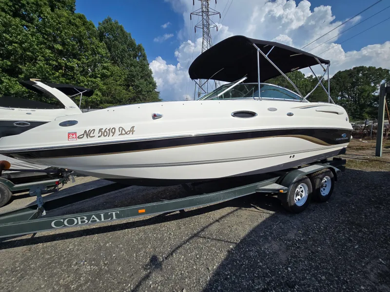 The Image of 2005 Chaparral 236 Sunesta boat on trailer, parked outdoors under a clear sky. - 0