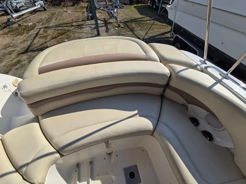 Slide: The Image of 2005 Chaparral 236 Sunesta boat interior with beige seating and cup holders. - 10