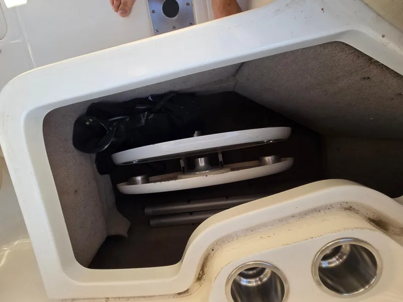 Slide: The Image of Storage compartment in a 2005 Chaparral 236 Sunesta boat, featuring cup holders and equipment. - 11