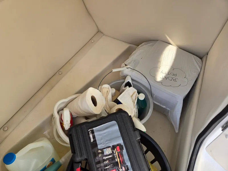 Slide: The Image of Storage compartment in 2005 Chaparral 236 Sunesta boat with cleaning supplies and tools. - 13