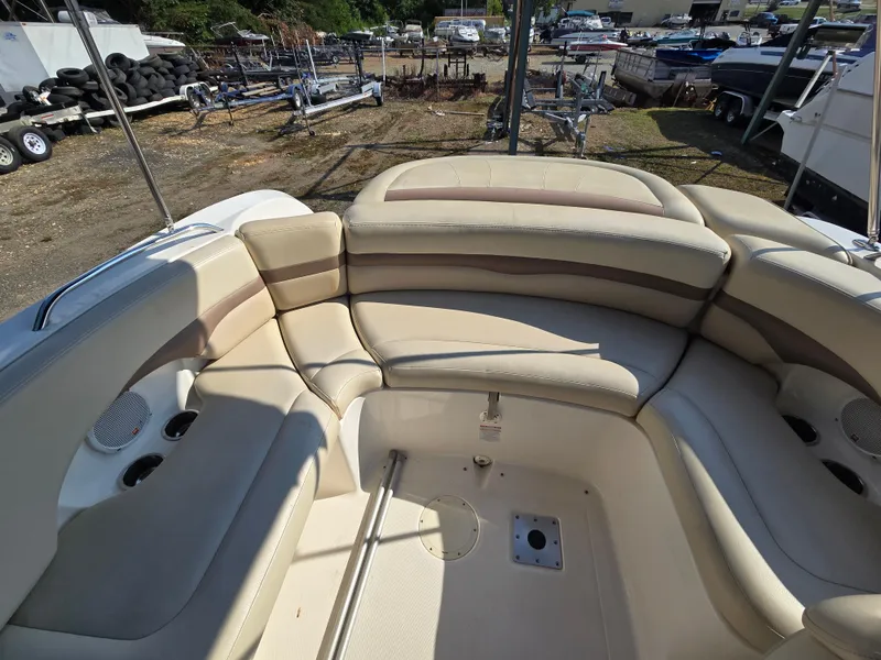 Slide: The Image of 2005 Chaparral 236 Sunesta boat interior with beige seating and cup holders. - 14