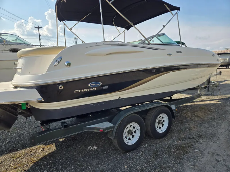 Slide: The Image of 2005 Chaparral 236 Sunesta boat on trailer with canopy, parked outdoors. - 2