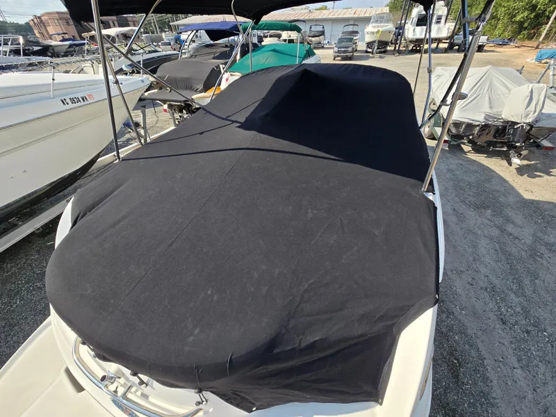 Slide: The Image of 2005 Chaparral 236 Sunesta boat covered with black tarp in a marina. - 23