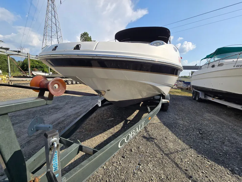 Slide: The Image of 2005 Chaparral 236 Sunesta boat on trailer, parked outdoors under a clear sky. - 27