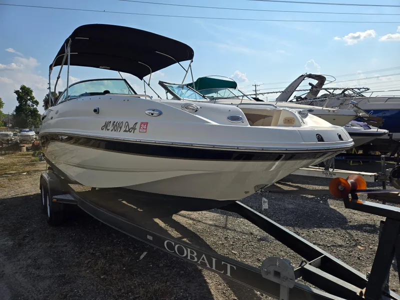 Slide: The Image of 2005 Chaparral 236 Sunesta boat on trailer, parked outdoors under clear sky. - 3