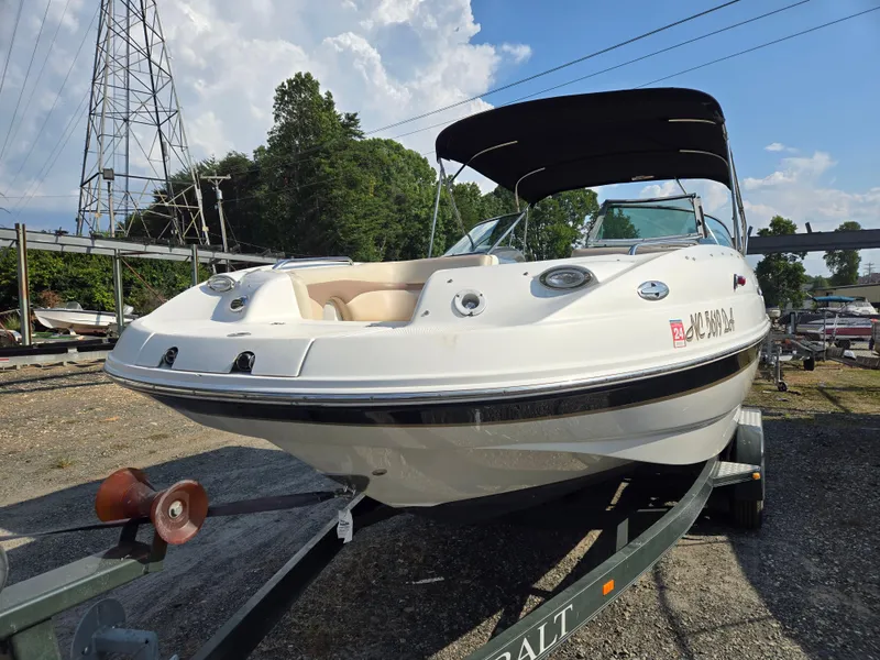 Slide: The Image of 2005 Chaparral 236 Sunesta boat on trailer, parked outdoors under a clear sky. - 4