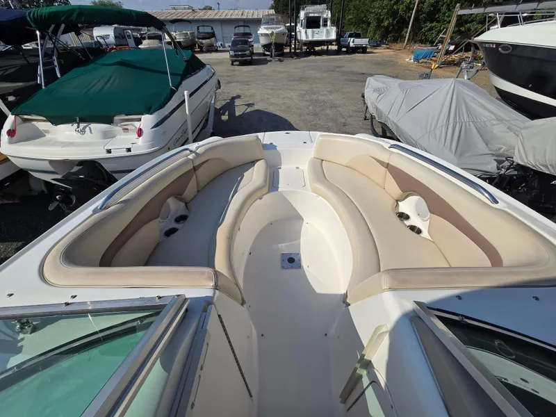 Slide: The Image of 2005 Chaparral 236 Sunesta boat with spacious seating, parked in a marina. - 6