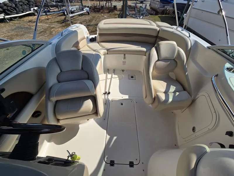 Slide: The Image of 2005 Chaparral 236 Sunesta boat interior with beige seating and steering wheel. - 9